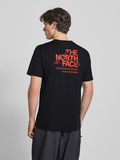 Mannenmodel draagt T-Shirt met Logo en Rundhalsausschnitt van The North Face, katoenmix, regular fit, logo, ronde hals, ruglengte maat M 72 cm. Ganzkörperansicht Rückansicht.