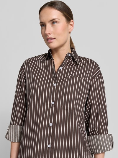 Frauenmodel trägt Regular Fit Bluse aus reiner Baumwolle Modell 'MAVIE' von VILLA SOPHIE, braunes Allover-Muster, Langarm, Nahaufnahme Oberkörper