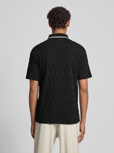 Männermodel trägt Regular Fit Poloshirt aus reiner Baumwolle Modell 'DUNIK' von HUGO in Schwarz mit strukturierter Allover-Optik, Ganzkörperansicht Rückansicht.