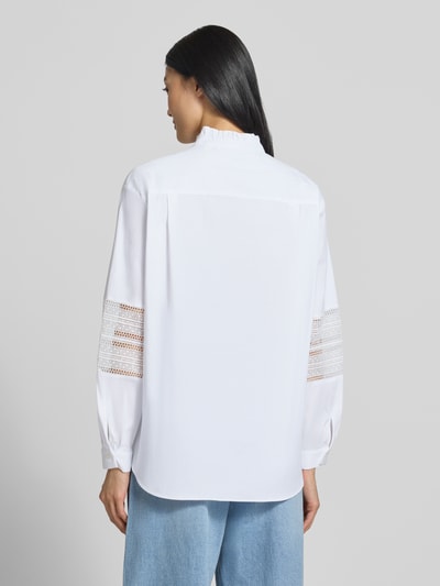 Frauenmodel trägt Regular Fit Bluse aus Baumwoll-Mix Modell 'Gala' von MANGO in Weiß mit Loch-Stitching, Ganzkörperansicht Rückansicht.