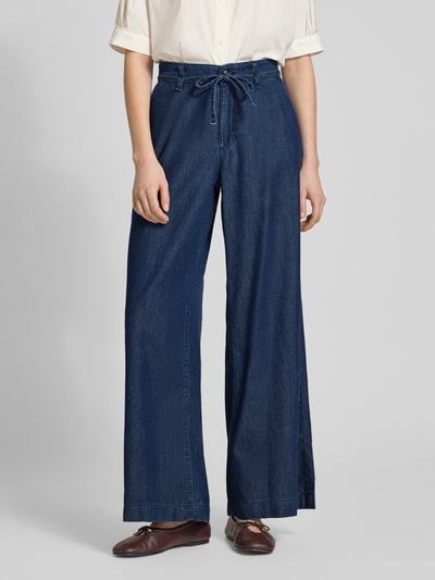 Frauenmodel trägt Wide Leg Jeans mit Bindegürtel Modell 'Wendy' von MAC aus Baumwoll-Lyocell-Mix in Dunkelblau, Ganzkörperansicht von vorne.