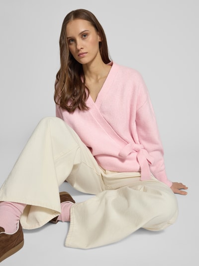 Frauenmodel trägt Regular Fit Cardigan mit Woll-Anteil Modell 'KIRA' von Only in Rosa, Strickoptik, Gürtel, unifarben, Nahaufnahme Oberkörper.