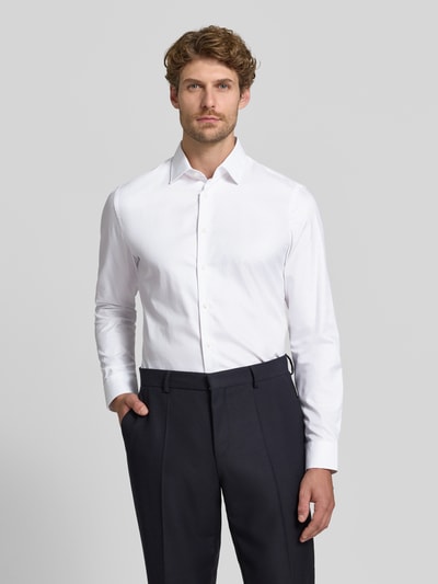 Männermodel trägt weißes Slim Fit Businesshemd aus reiner Baumwolle von Jake*s, glatte Textur, dunkle Hose, Ganzkörperansicht von vorne.