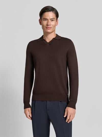 Männermodel trägt dunkelbraunen Strickpullover mit Viskose-Anteil Modell 'MANICA LUNGA' von MARKUP, glatte Textur, gerader Schnitt, Umlegekragen, Ganzkörperansicht von vorne, Herrenmode.
