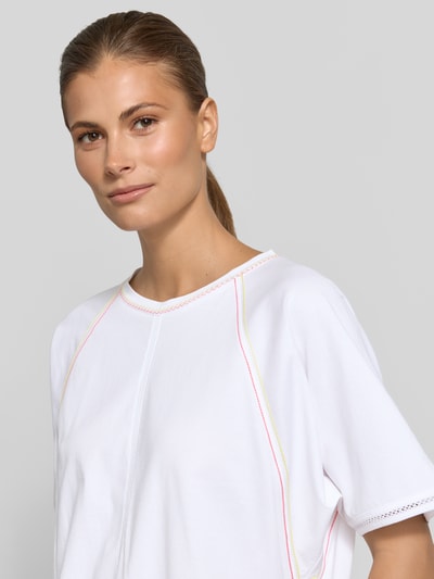 Kobiece modelka nosi Relaxed Fit T-Shirt mit Rundhalsausschnitt von Marc Cain, damski t-shirt z bawełny, ozdobne szwy, długość tyłu w rozmiarze 36: 52 cm, zbliżenie na górną część ciała