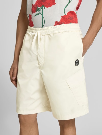 Männermodel trägt Straight Fit Shorts mit Cargo-Taschen von Kenzo, elastischer Bund, helles Beige, Nahaufnahme Oberkörper.