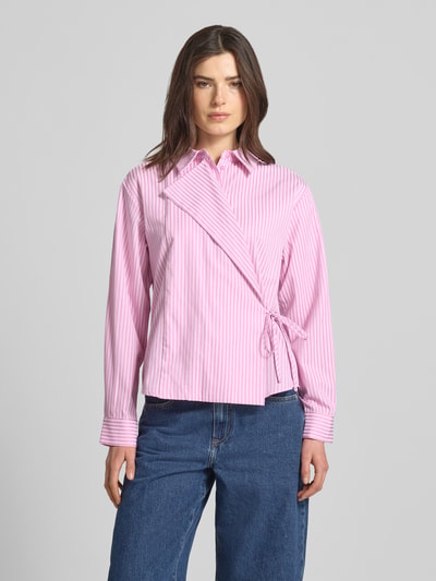 Frauenmodel trägt Regular Fit Hemdbluse mit Viskose-Anteil Modell 'WITO' von YAS, rosa mit weißen Streifen, Wickel-Optik, Schnürung, Kentkragen, Baumwoll-Mix, Ganzkörperansicht von vorne.