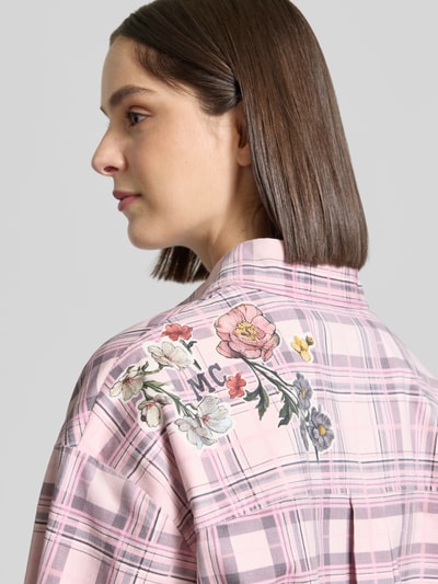 Frauenmodel trägt Regular Fit Hemdbluse aus Baumwoll-Mix von Marc Cain mit floralem Print auf rosa kariertem Stoff, Detailaufnahme Schulter, KI-modifiziertes Bild.