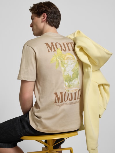 Männermodel trägt Regular Fit T-Shirt aus reiner Baumwolle Modell 'FRED' von Only & Sons in uni beige mit Motiv-Print, Rückansicht