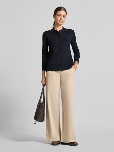 Frauenmodel trägt Strickjacke aus reiner Schurwolle Modell 'DETTO' von MM by Max Mara, Dunkelblau, körpernahe Passform, Ganzkörperansicht von vorne.