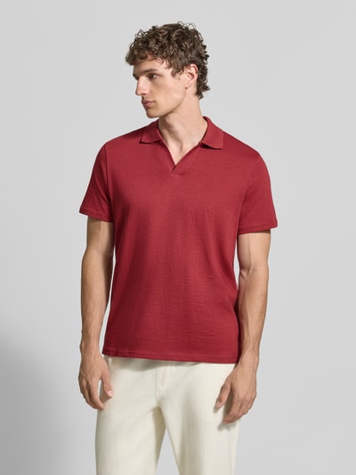 Männermodel trägt Slim Fit Poloshirt mit V-Ausschnitt von MCNEAL aus reiner Baumwolle in Rot, glatte Struktur, Ganzkörperansicht von vorne.