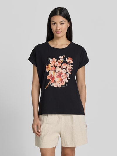 Frauenmodel trägt Damen T-Shirt mit Motiv-Print Modell 'RINA' von Soyaconcept, Baumwoll-Elasthan-Mix, Regular-Fit, Rundhalsausschnitt, Ärmel mit Aufschlag, schwarze Grundfarbe mit buntem Print, Rückenlänge bei Größe S 61 cm, Ganzkörperansicht von vorne.