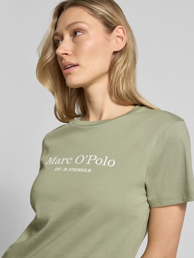 Vrouwenmodel draagt Regular Fit T-Shirt uit zuivere katoen van Marc O'Polo, effen, labelprint, ronde hals, korte mouw, Nahaufnahme bovenlichaam.