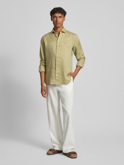 Męski model nosi Slim Fit Leinenhemd mit Haifischkragen von Fynch-Hatton, len, krój slim fit, wyhaftowane logo, kołnierzyk typu cutaway, długość tyłu w rozmiarze M 77 cm, szerokość ramion w rozmiarze M 47 cm, długość rękawów w rozmiarze M 61 cm, widok całej sylwetki z przodu