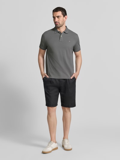 Mężczyzna nosi Regular Fit Poloshirt aus reiner Baumwolle von GANT w kolorze szarym, jednolita struktura, Ganzkörperansicht von vorne.