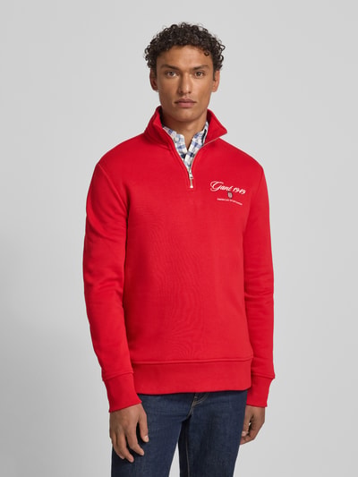 Männermodel trägt Sweatshirt mit Stehkragen und Reißverschluss von Gant in Rot, Baumwoll-Mix, Regular-Fit, Label-Stitching, Nahaufnahme Oberkörper.