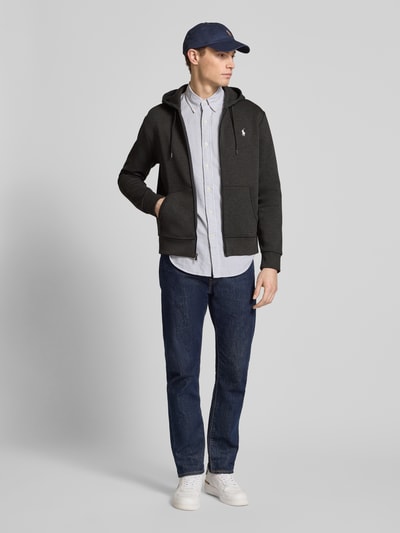 Männermodel trägt Regular Fit Sweatjacke aus Baumwoll-Mix von Polo Ralph Lauren in Dunkelgrau mit Kapuze, Reißverschluss und Label-Stitching, Ganzkörperansicht von vorne.