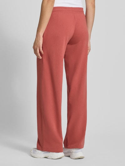 Frauenmodel trägt Sweatpants mit Tunnelzug von REVIEW in Ziegelrot, Baumwoll-Mix, Gerader-Schnitt, elastischer Bund, Ganzkörperansicht Rückansicht.