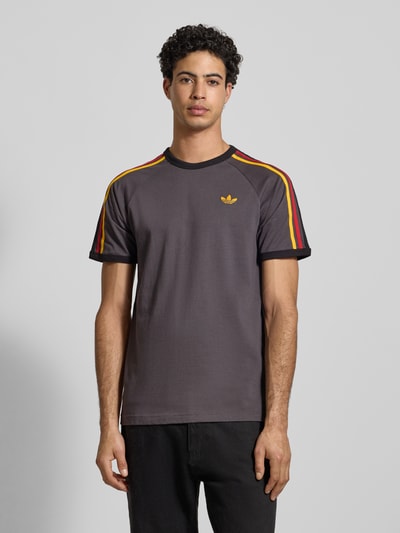 Männermodel draagt T-shirt met Labelstitching van adidas Originals in antraciet, puur katoen, regular fit, ribboorden, ronde hals, ruglengte 73 cm, Ganzkörperansicht van voren.