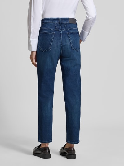 Männermodel trägt Straight Fit Jeans aus Mieszanka bawełny marki Closed Modell 'PEDAL PUSHER', kolor ciemnoniebieski, kieszenie z tyłu, skrócony krój, zapięcie na guzik i zamek błyskawiczny, nadruk z napisem, szerokość w rozmiarze 27/32: 33 cm, długość wewnętrzna nogawki w rozmiarze 27/32: 69 cm. Ganzkörperansicht Rückansicht.