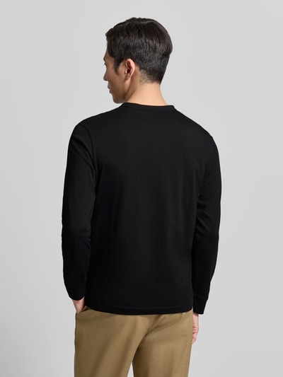 Männermodel trägt Regular Fit Langarmshirt aus reiner Baumwolle von Tom Tailor in Schwarz, unifarben, Jersey, Ganzkörperansicht Rückansicht.