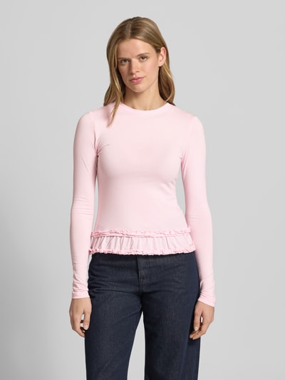 Frauenmodel trägt Longsleeve mit Rüschen Modell 'Mariella' von OH APRIL in Rosa, Baumwoll-Mix mit Viskose-Anteil, Körpernaher-Schnitt, Rundhalsausschnitt, Logo-Stitching, Rückenlänge bei Größe S: 54 cm, Ganzkörperansicht von vorne.
