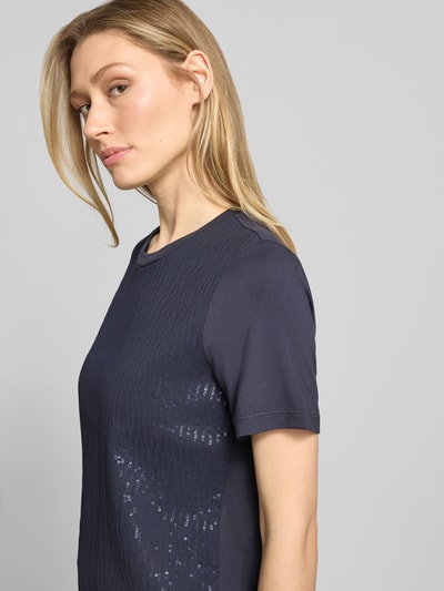 Frauenmodel trägt T-Shirt aus Viskose-Mix mit Pailletten von Comma, dunkelblau, Strukturmuster, Rundhalsausschnitt, Regular-Fit, Nahaufnahme Oberkörper.