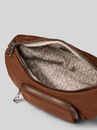 Produktfoto, Bauchtasche mit Logo-Detail Modell 'Janica' von BOGNER in Braun mit silberfarbenem Reißverschluss, glatte Textur, Innenfutter mit BOGNER-Schriftzug, Hauptfach und Frontfach sichtbar, Maße und Riemen laut Kontext.