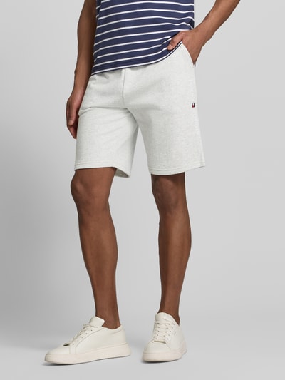 Männermodel trägt Relaxed Fit Sweatshorts aus Baumwoll-Mix von Tommy Hilfiger in Optik: Melange, Label-Stitching-Applikation, Nahaufnahme Unterkörper.