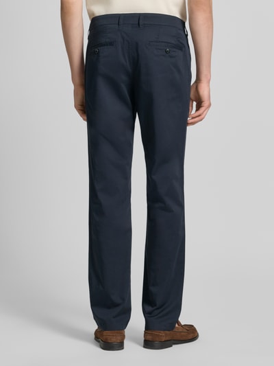 Männermodel trägt Chino mit Eingrifftaschen von Christian Berg Men aus Baumwoll-Elasthan-Mix in Regular-Fit, dunkelblau, Ganzkörperansicht Rückansicht.