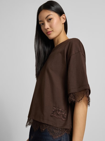 Frauenmodel trägt T-Shirt mit Spitzenbesatz von Smith and Soul in Dunkelbraun aus reiner Baumwolle, gerader Schnitt, Nahaufnahme Oberkörper.