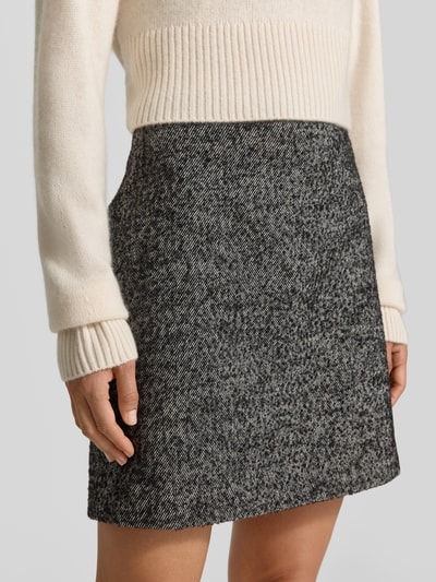 Frauenmodel trägt Straight Fit Minirock mit Woll-Anteil von MYON, Strukturmuster in Grau, Nahaufnahme Oberkörper, Material-Mix sichtbar.