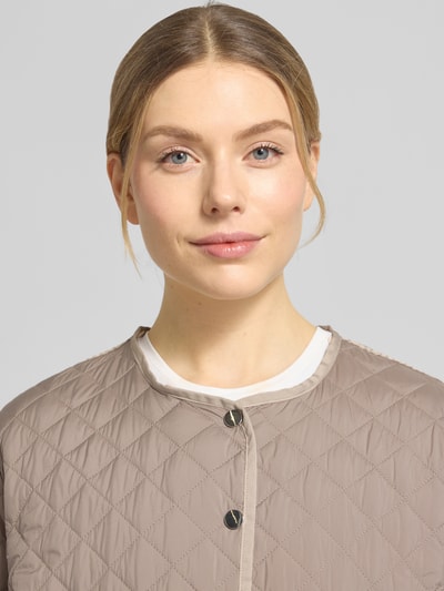 Kobiece modelka nosi Steppmantel mit Druckknopfleiste von WHITE LABEL, jasnobeżowy, pikowana faktura, Nahaufnahme górnej części ciała, luźny krój, kapuza, szerokość w rozmiarze 36: 55 cm, długość tyłu: 74 cm, szerokość ramion: 46 cm, długość rękawa: 61 cm.