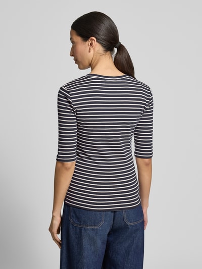 Frauenmodel trägt Longsleeve mit 3/4-Arm und V-Ausschnitt von Christian Berg Woman, aus Baumwoll-Mix mit Stretch-Anteil, Straight Fit, Rückenlänge bei Größe S 54 cm, gestreiftes Design in Dunkelblau und Weiß, glatte Textur, Ganzkörperansicht Rückansicht.