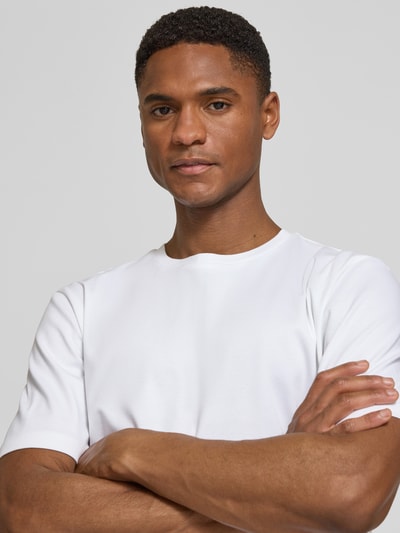 Männermodel trägt T-Shirt mit Rundhalsausschnitt von bugatti, reine Baumwolle, Slim Fit, weiß, glatte Textur, Nahaufnahme Oberkörper.