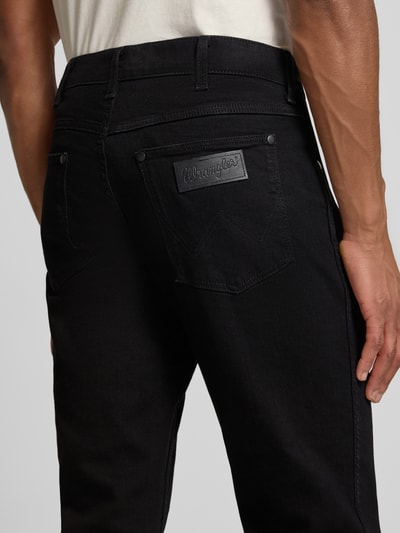 Männermodel trägt Straight Fit Jeans im 5-Pocket-Design Modell 'Greensboro' von Wrangler, schwarze Baumwoll-Mix, Detailaufnahme Rückansicht. Herren, Stretch-Anteil, Gerader-Schnitt, Knopf-Reißverschluss, Bundweite 43 cm, Innenbeinlänge 80 cm.