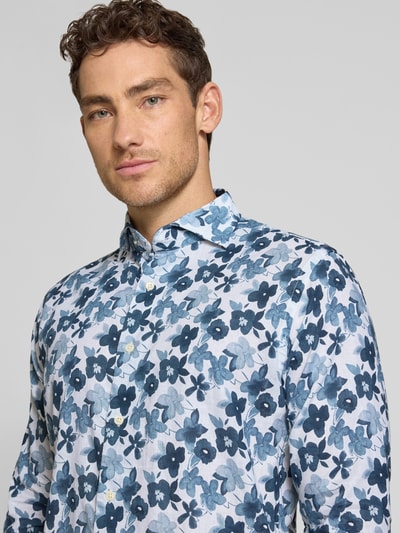 Männermodel trägt Slim Fit Business-Hemd aus Leinen-Baumwoll-Mix Modell 'Roma' von FIL NOIR, florales Blau-Weiß-Muster, Nahaufnahme Oberkörper.