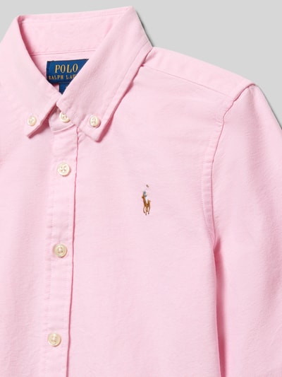 Meisje draagt Regular Fit Hemdbluse aus reiner Baumwolle Modell 'TRINETTEOX-SHIRTS-BUTTON' van Polo Ralph Lauren Teens, lichtroze uni, piqué, knopenrij, logo-stiksel, button-down kraag, manchetten, detailopname bovenlichaam.