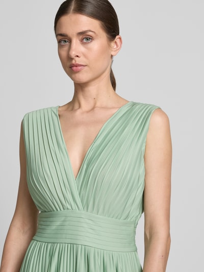 Kobiece model prezentuje sukienka wieczorowa z szyfonu Abendkleid mit V-Ausschnitt Modell 'Linnea' od GUIDO MARIA KRETSCHMER WOMAN, kolor pastelowozielony, taliowany fason, plisy, dekolt w serek z przodu i z tyłu, wszyty zamek błyskawiczny z boku, długość tyłu w rozmiarze 36: 118 cm, szerokość klatki piersiowej w rozmiarze 36: 32 cm, zbliżenie na górną część sylwetki