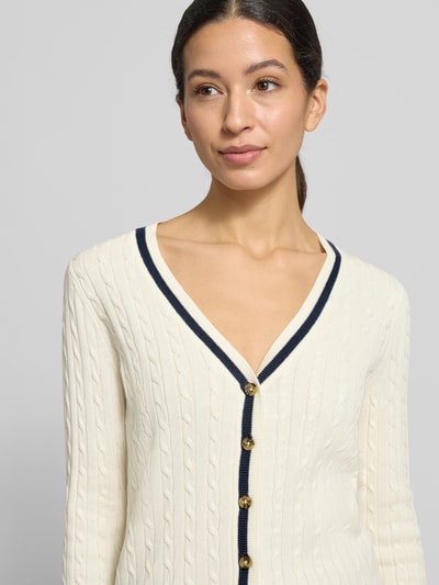 Vrouwenmodel draagt Strickjacke mit V-Ausschnitt van Christian Berg Woman, beige, kabelstructuur, knoopsluiting, katoenmengsel, close-up bovenlichaam.
