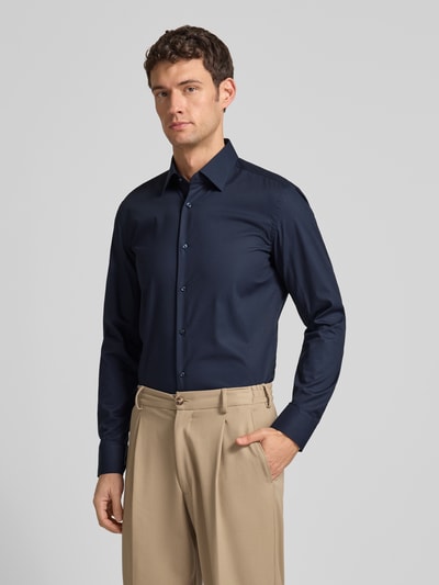 Męski model nosi Slim Fit Businesshemd aus Popeline mit Stretch-Anteil von BOSS, granatowa koszula, długi rękaw, widok z przodu, Ganzkörperansicht von vorne. Koszula z mieszanki bawełny i elastanu, kołnierz kent, sportowe mankiety, zaokrąglony dół, easycare, długość tyłu 76 cm, szerokość ramion 47 cm, długość rękawa 67 cm.