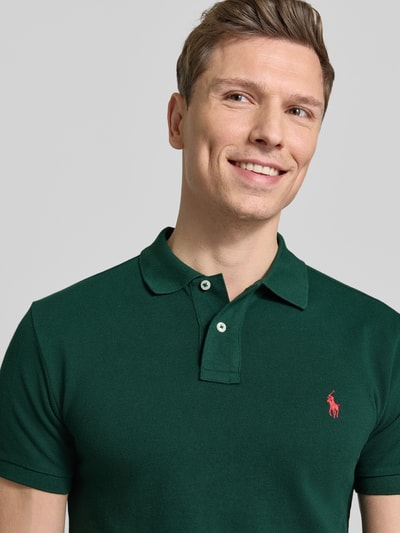 Männermodel trägt Slim Fit Poloshirt aus reiner Baumwolle von Polo Ralph Lauren in Optik: Unifarben mit Logo-Stitching, Nahaufnahme Oberkörper.