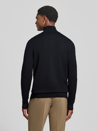 Männermodel trägt Modern Fit Troyer aus reiner Schurwolle Modell 'Dario' von JOOP! COLLECTION in Schwarz und Beige, Ganzkörperansicht Rückansicht.