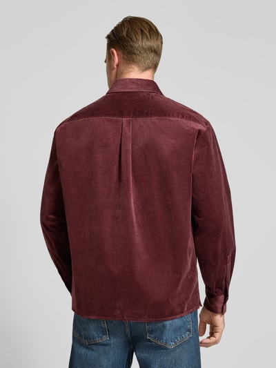 Männermodel trägt Regular Fit Cordhemd mit Kentkragen von DRYKORN in Bordeaux, feine Cordstruktur, Brusttasche, Ganzkörperansicht Rückansicht. Baumwoll-Elasthan-Mix, langärmliges Design, Rückenlänge 72 cm, Schulterbreite 53 cm, Ärmellänge 60 cm.