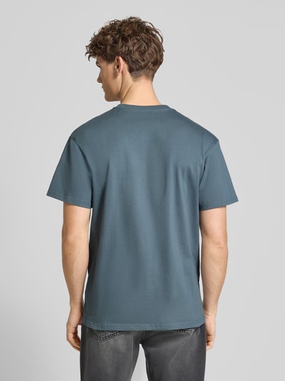 Männermodel trägt Regular Fit T-Shirt mit Logo-Stitching Modell 'Chase' von Carhartt Work In Progress aus Reine Baumwolle, Rückenlänge 72 cm, Rückenansicht.