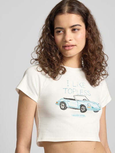 Frauenmodel trägt Cropped T-Shirt mit Motiv-Print von ANOTHER COTTON LAB aus Reine Baumwolle in Offwhite mit Rundhalsausschnitt, Nahaufnahme Oberkörper.