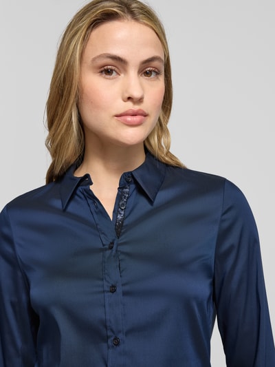 Frauenmodel trägt Hemdbluse mit Knopfleiste von ETERNA, dunkelblau, Kentkragen, lockerer Schnitt, Nahaufnahme Oberkörper.