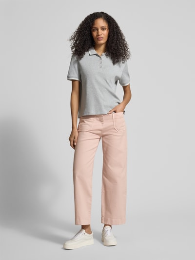Modelka kobieca nosi Regular Fit Poloshirt aus Baumwolle von Jake*s Casual w kolorze jasnoszarym, krój regular fit, kołnierzyk polo, elastyczne zakończenia rękawów, długość tyłu w rozmiarze M: 54 cm, widok całej sylwetki z przodu.