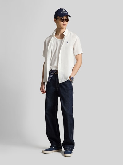 Mannenmodel draagt Regular Fit Leinenhemd mit Button-Down-Kragen van Polo Ralph Lauren, look: effen, regular fit pasvorm, button-downkraag, doorlopende knoopsluiting, gestikt logo, korte mouw, licht afgeronde rompzoom, materiaal: puur linnen. Ganzkörperansicht van voren.