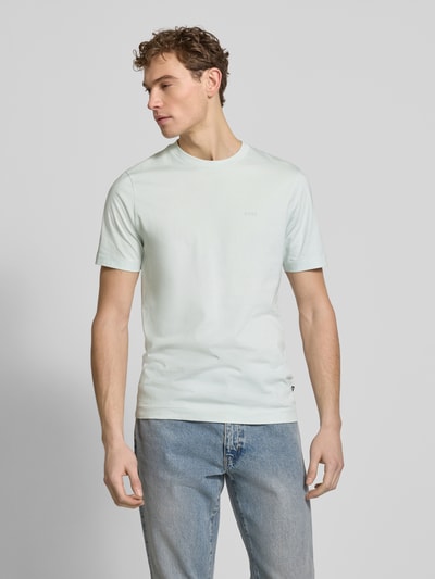 Männermodel trägt Regular Fit T-Shirt aus reiner Baumwolle Modell 'THOMPSON' von BOSS in Hellblau, unifarben, mit Label Print, Ganzkörperansicht von vorne.